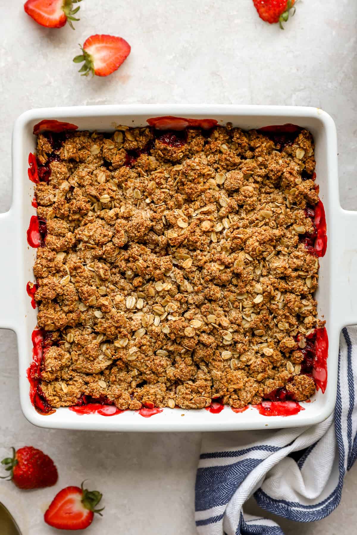A baked strawberry crisp in a square baking dish. 