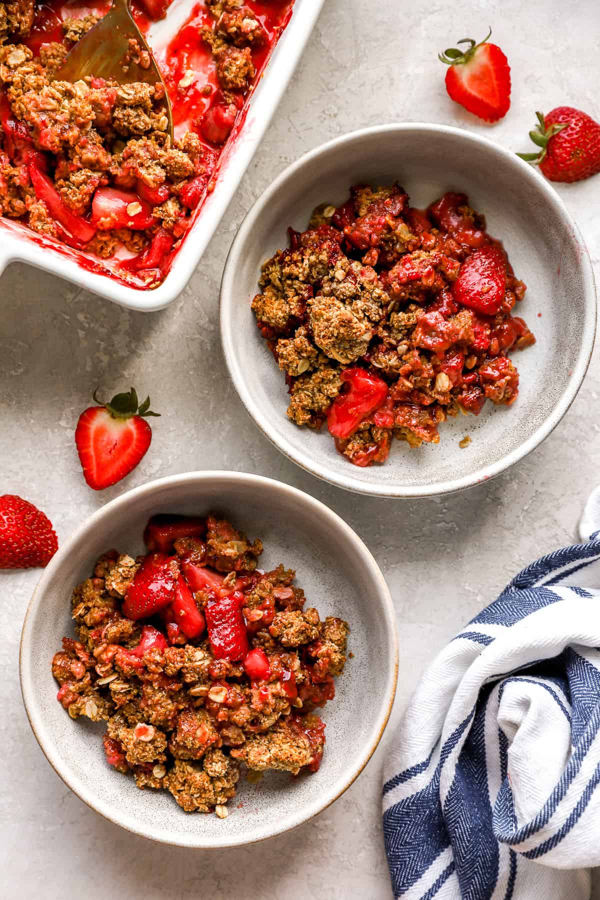 Two bowls of strawberry crisp with oats.