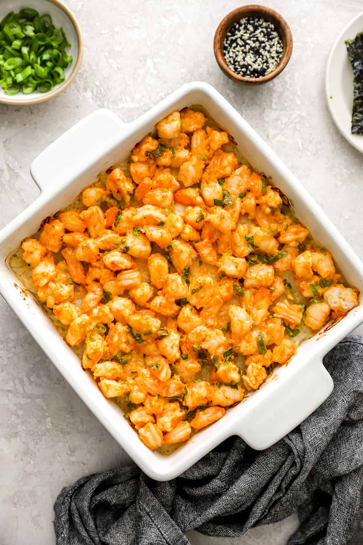 Cooked shrimp sushi bake in a square dish. 