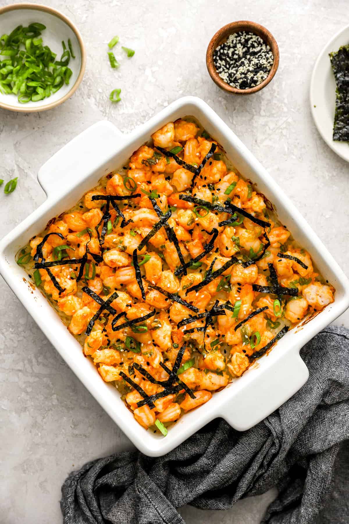 Seaweed strips on top of a shrimp sushi bake. 