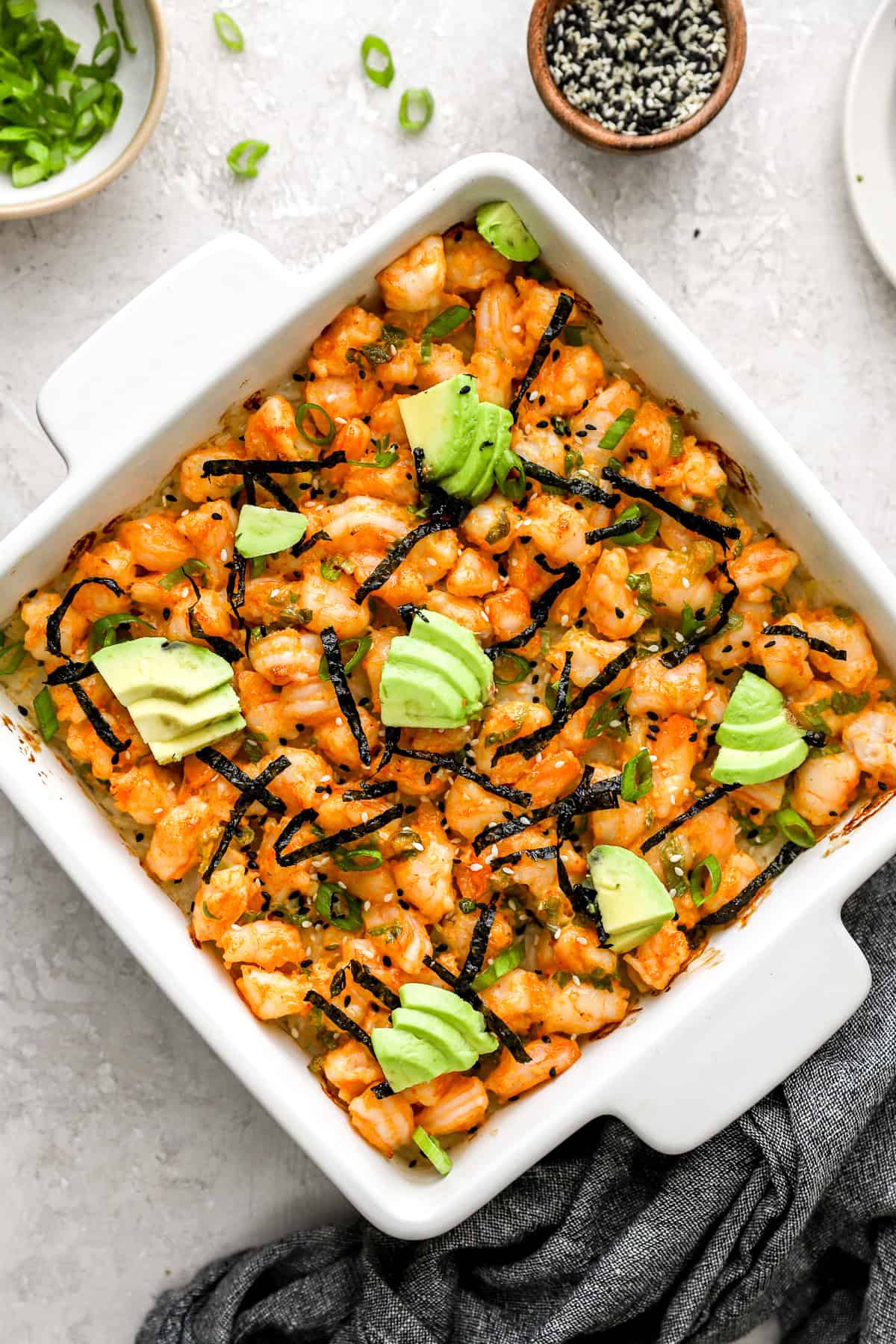 Shrimp sushi baked topped with seaweed and avocado. 