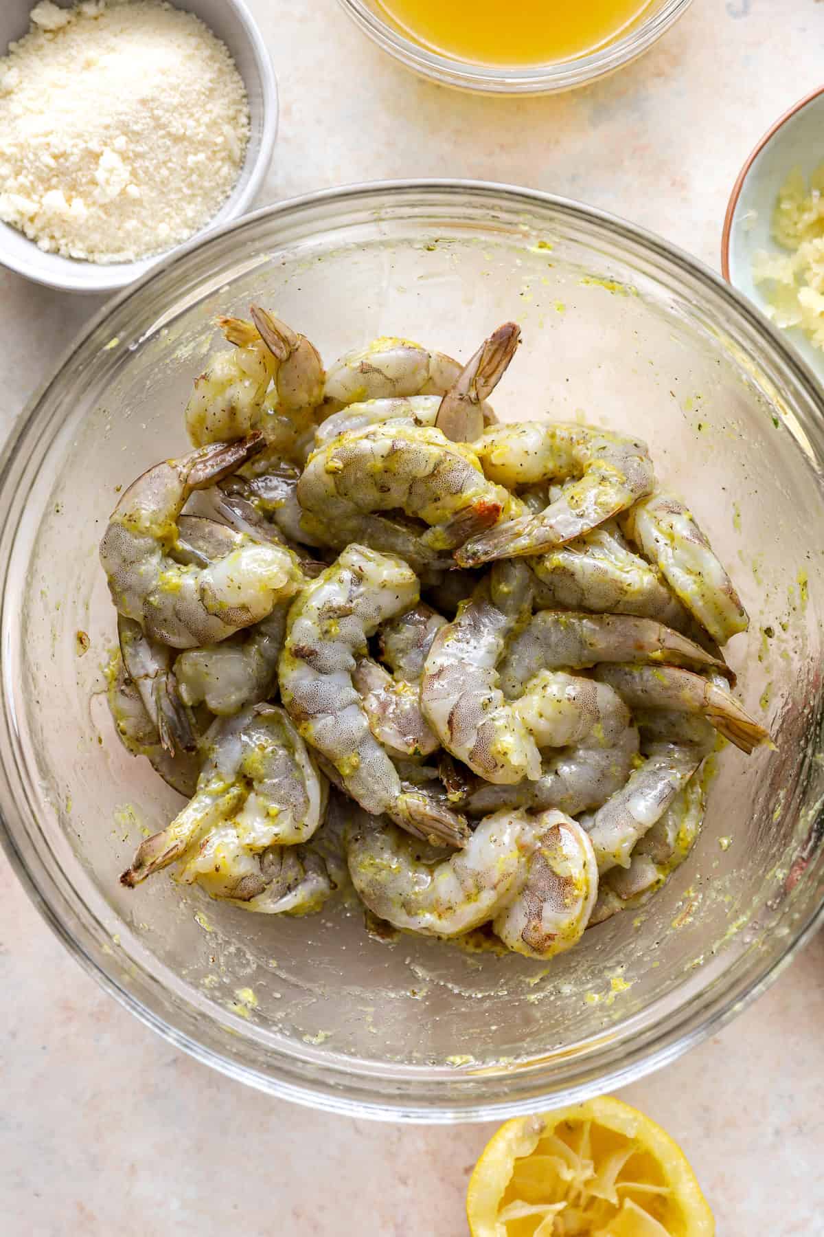 Raw shrimp in a bowl of marinade. 