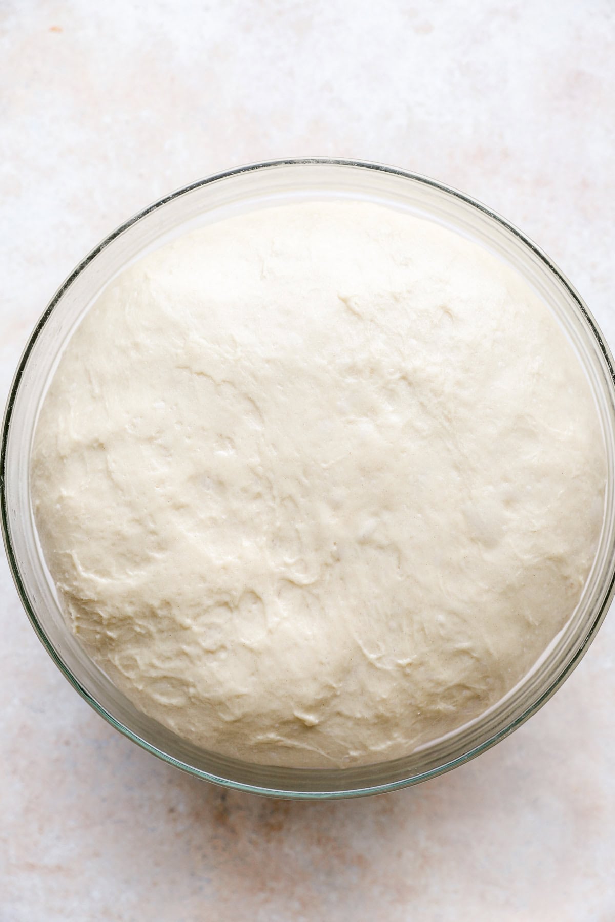 Proofed Challah bread dough in a bowl.