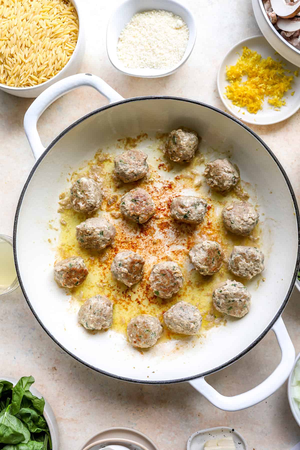 Meatballs searing in a pot.