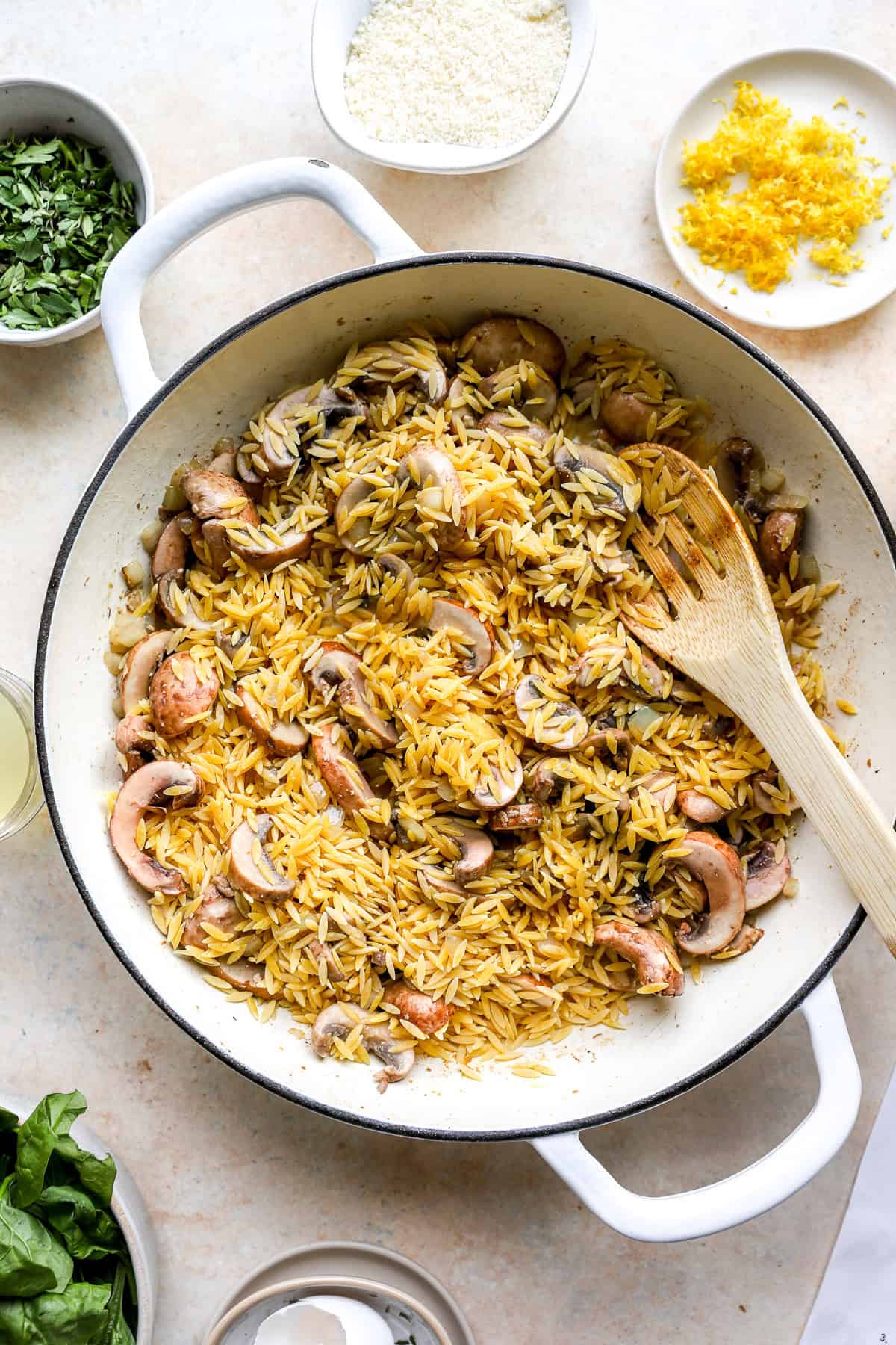 Orzo and mushrooms in a pot.