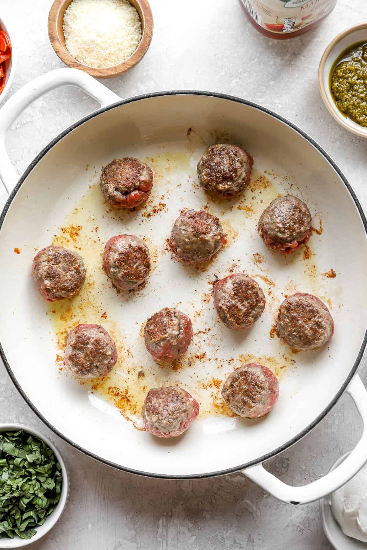 Meatballs browning in a skillet. 