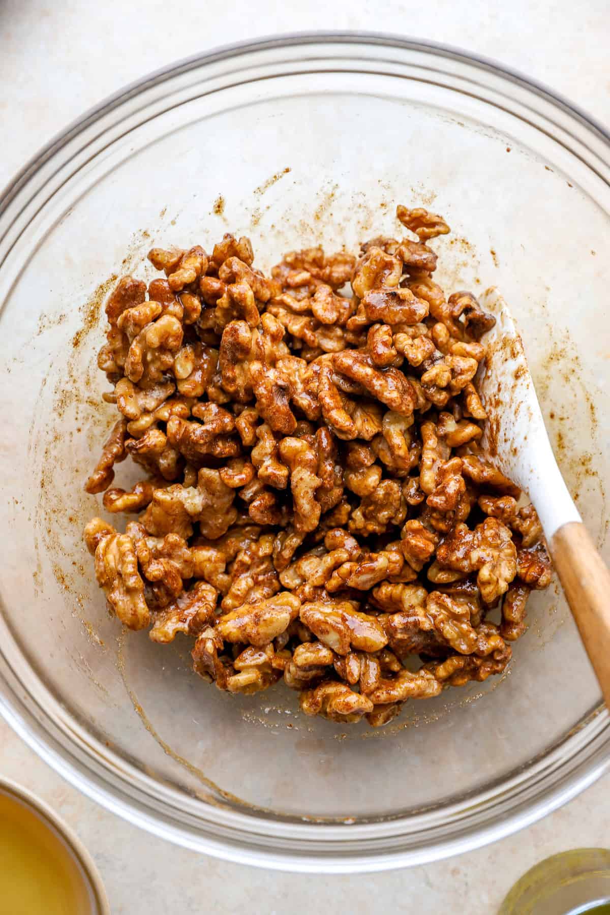 Walnuts being tossed with egg whites and a spice blend.