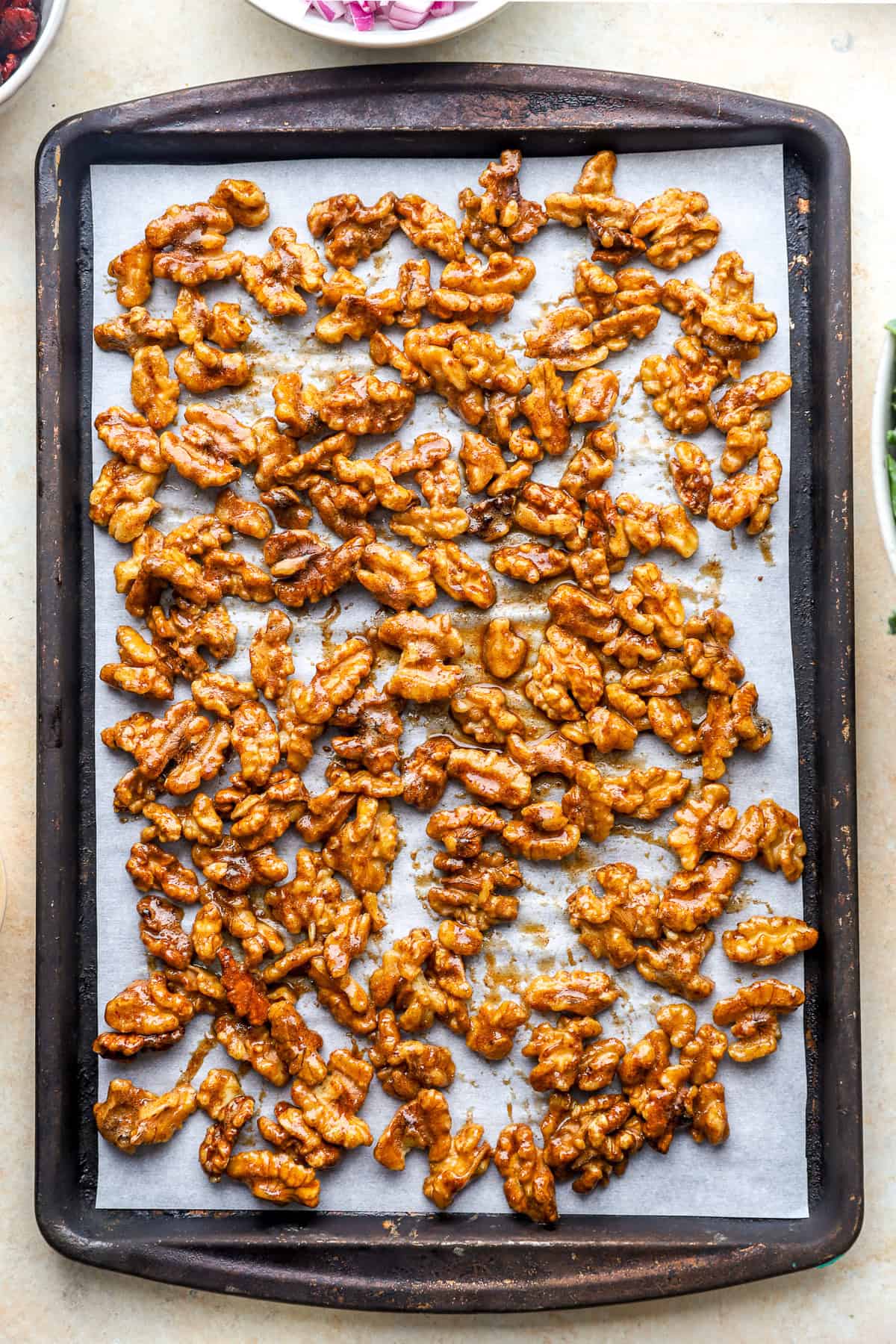 Candied walnuts on a baking shet.