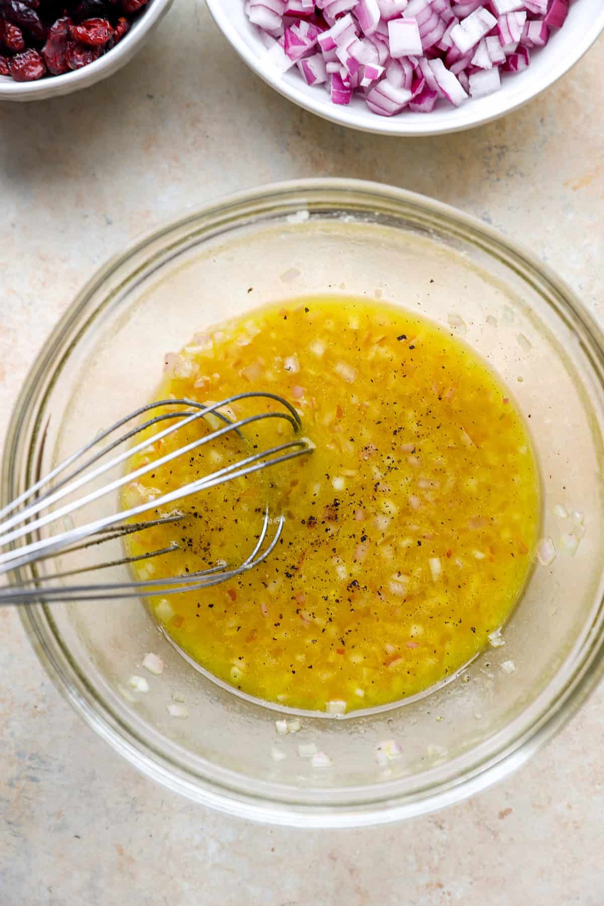 Shallot vinaigrette being whisked in a bowl.