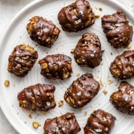 A plate of chocolate covered baklava stuffed dates.