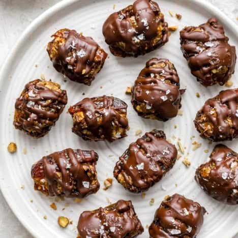 A plate of chocolate covered baklava stuffed dates.