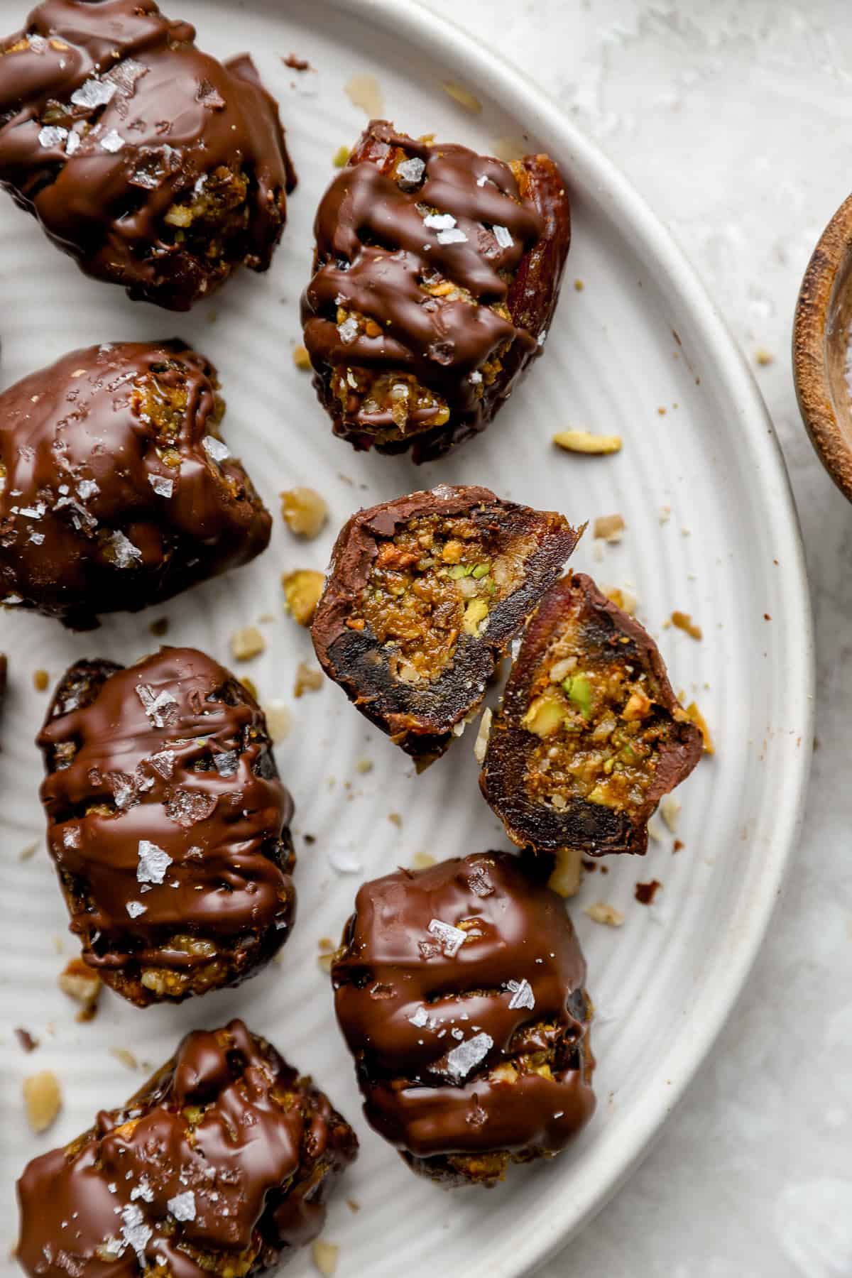A plate of baklava stuffed dates, one split in half.