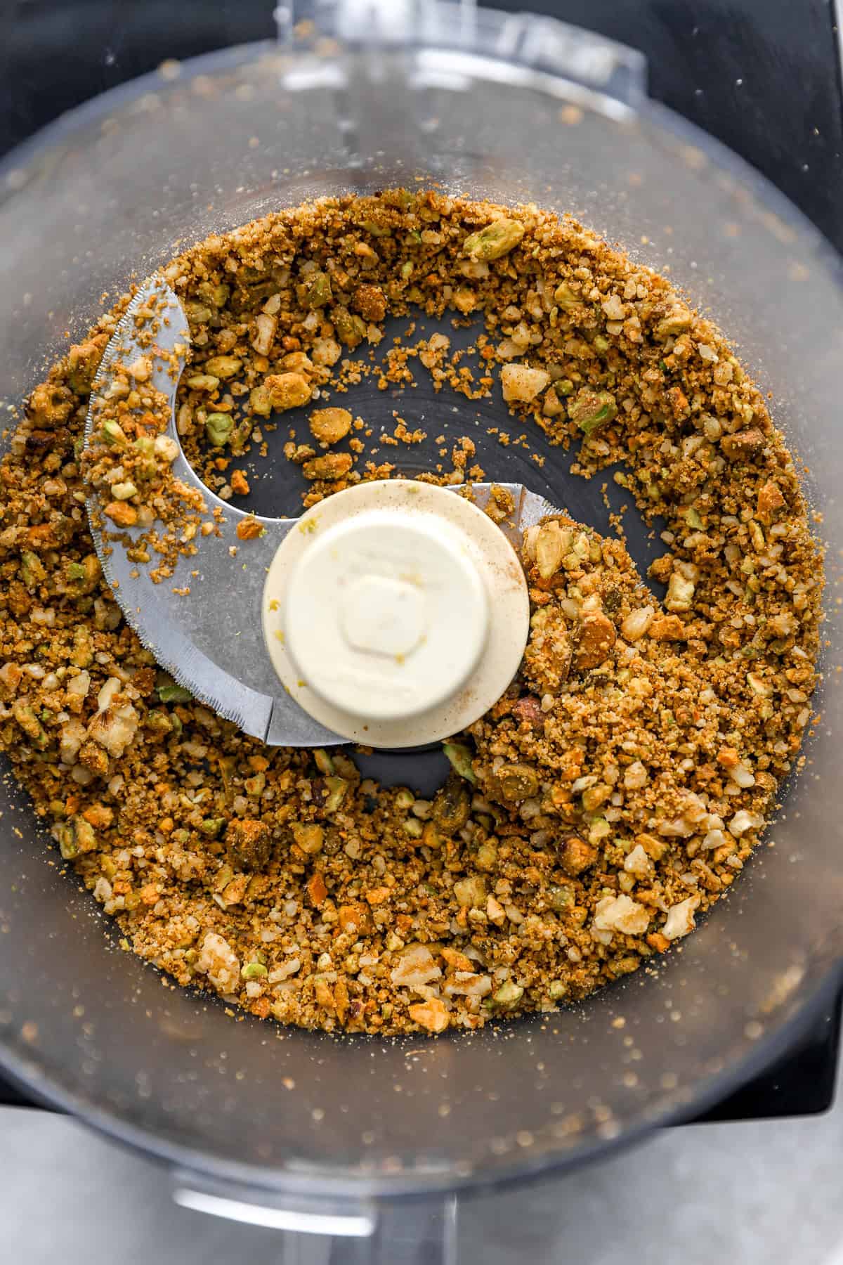 Nuts and spices being blended in a food processor.