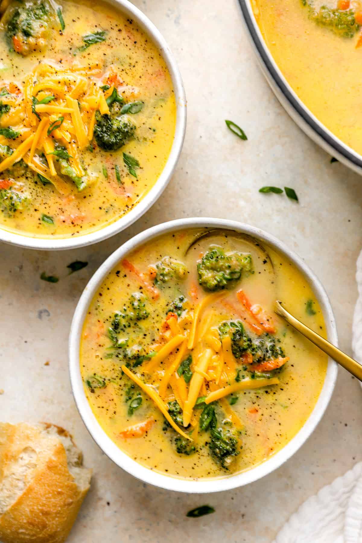 Two bowls of healthy broccoli cheddar soup. 