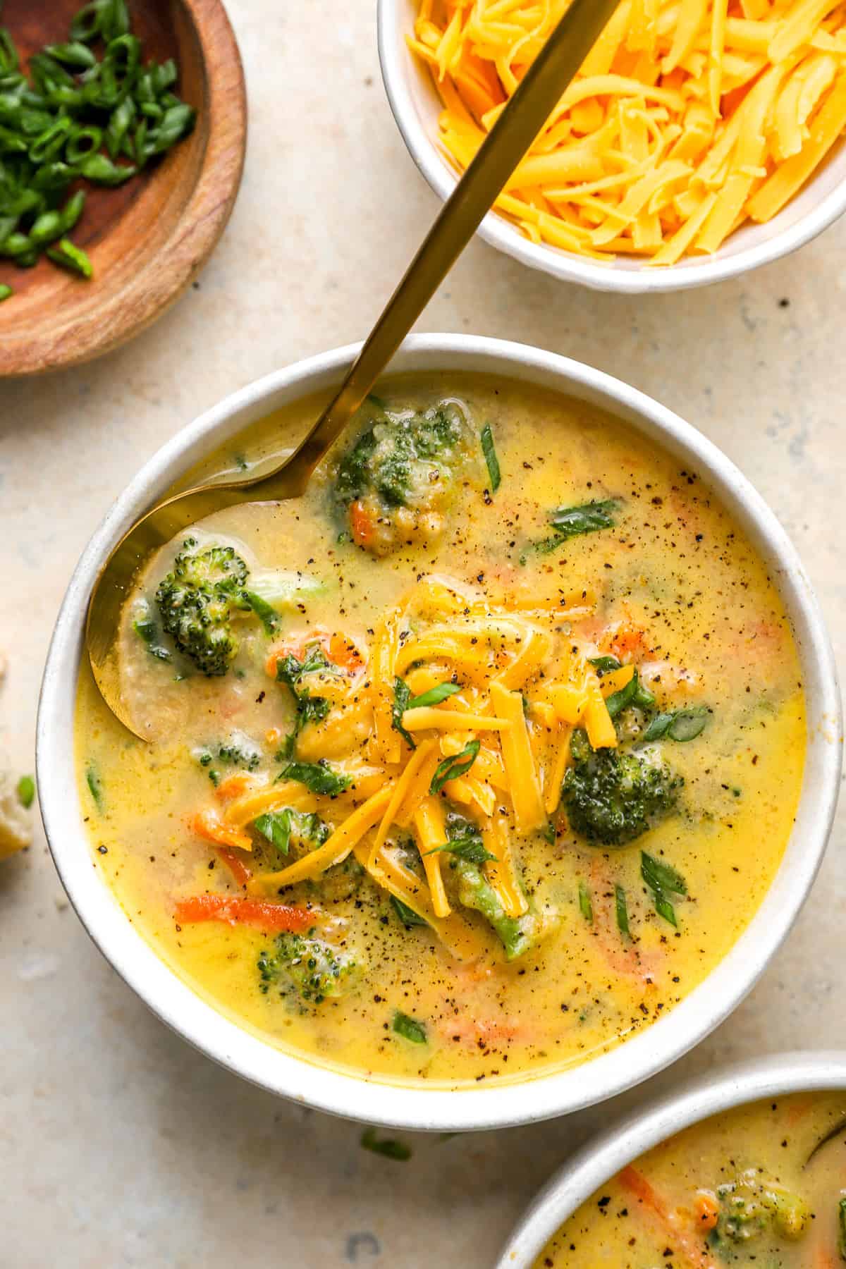 A bowl of broccoli cheddar soup with a spoon sticking out. 