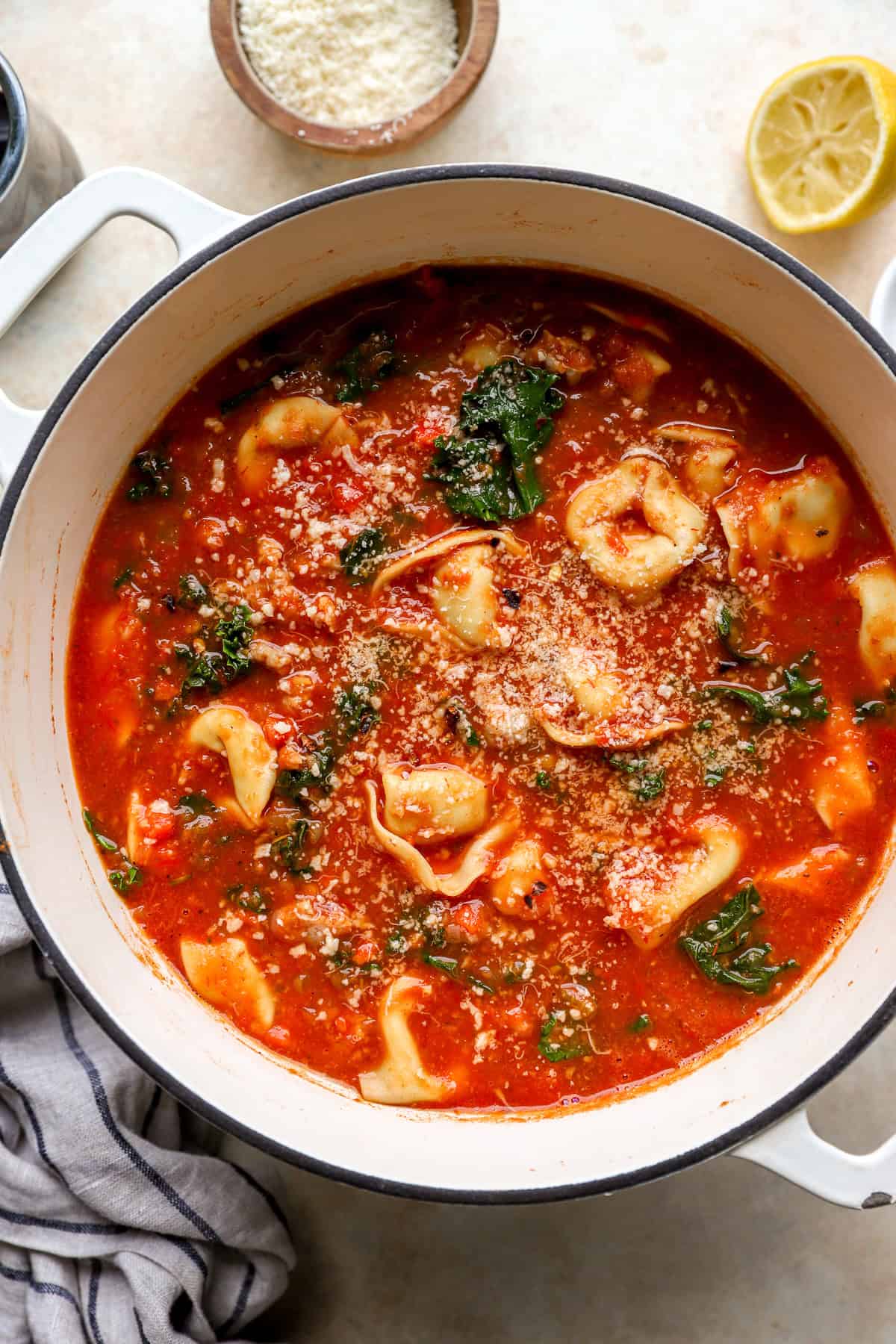 Seasonings being added to a pot of tortellini soup. 