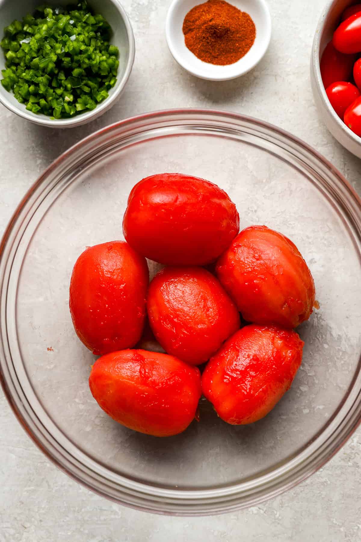 Six peeled tomatoes in a bowl.
