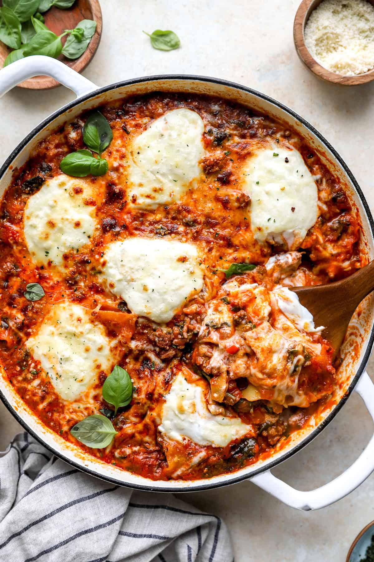A pot of skillet lasagna with a wooden spoon sticking out.