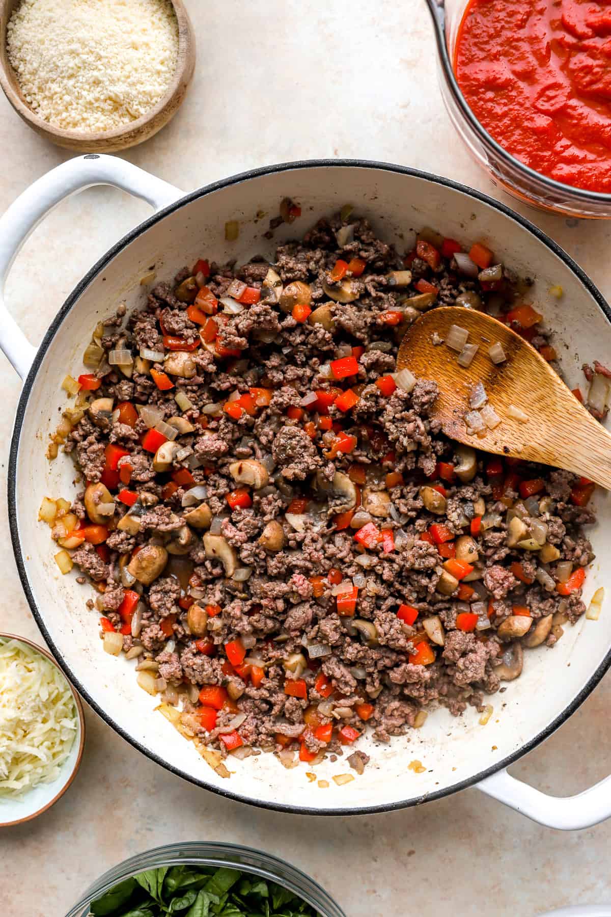 Ground beef browning in a skillet with veggies.