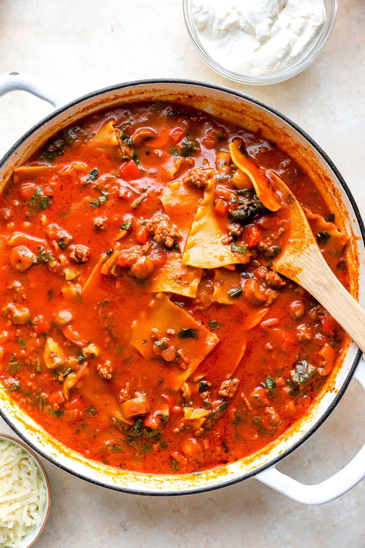 Marinara sauce in a skillet with ground beef and veggies.