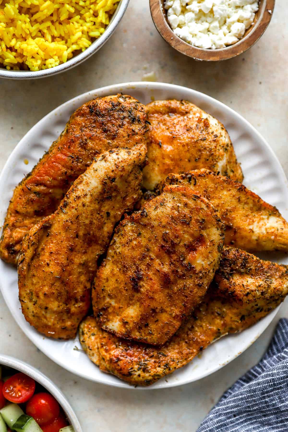 A white plate of cooked skillet chicken cutlets.