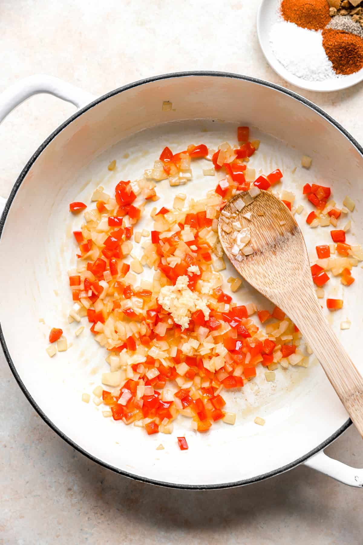 Onions, peppers, and garlic sautéing in a skillet. 