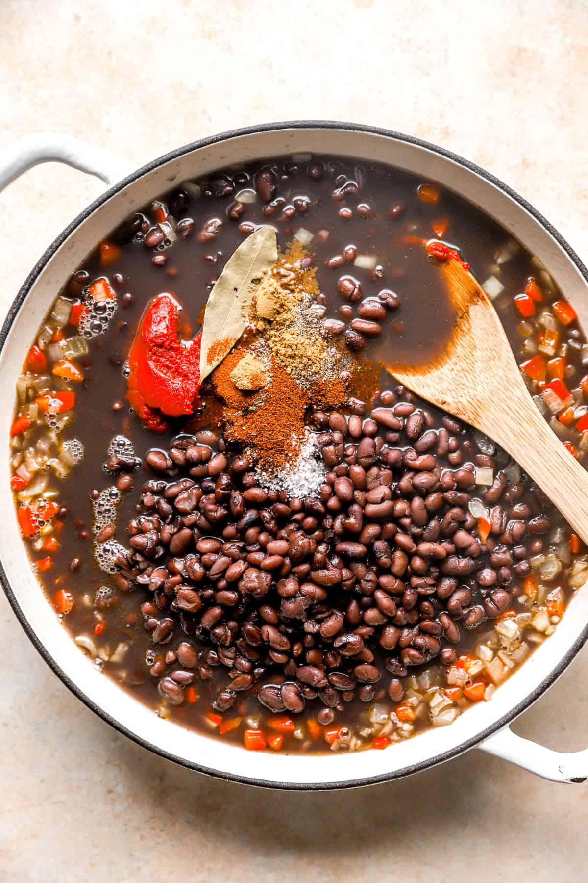 Instant Pot black beans combined in a skillet with broth, spices, and veggies. 