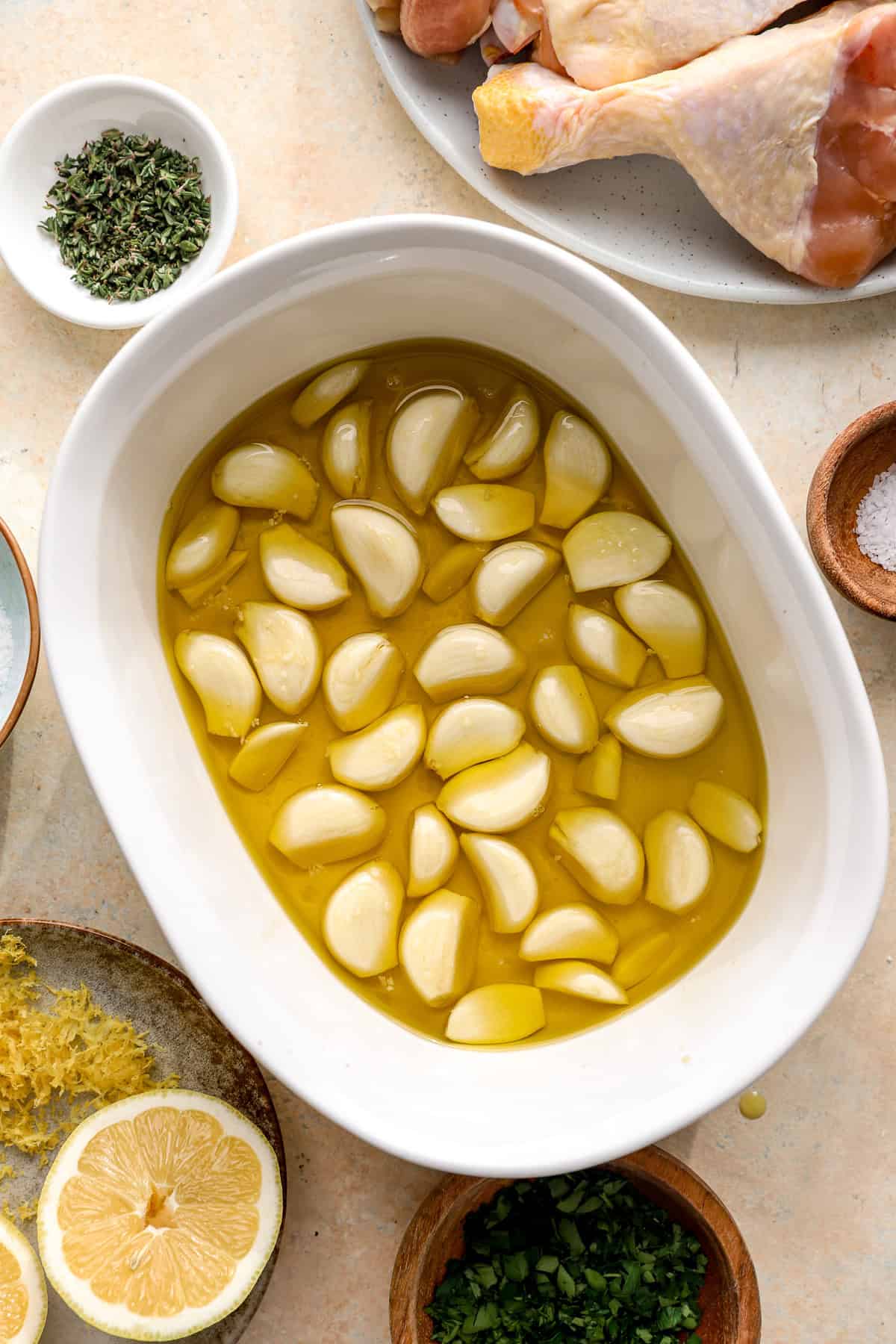 Garlic cloves and olive oil in a baking dish.