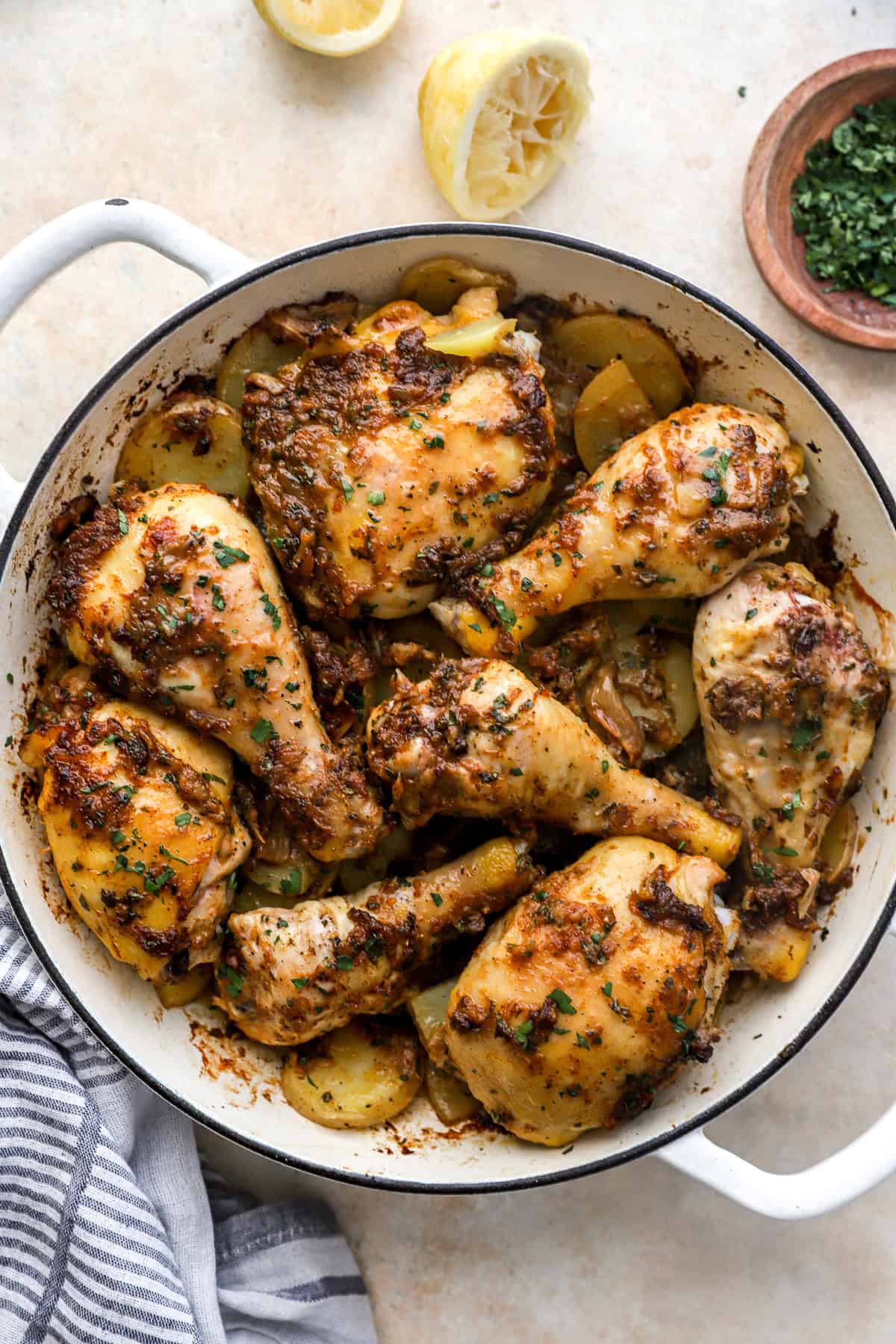 Garlic confit roasted chicken with potatoes in a braising pan.
