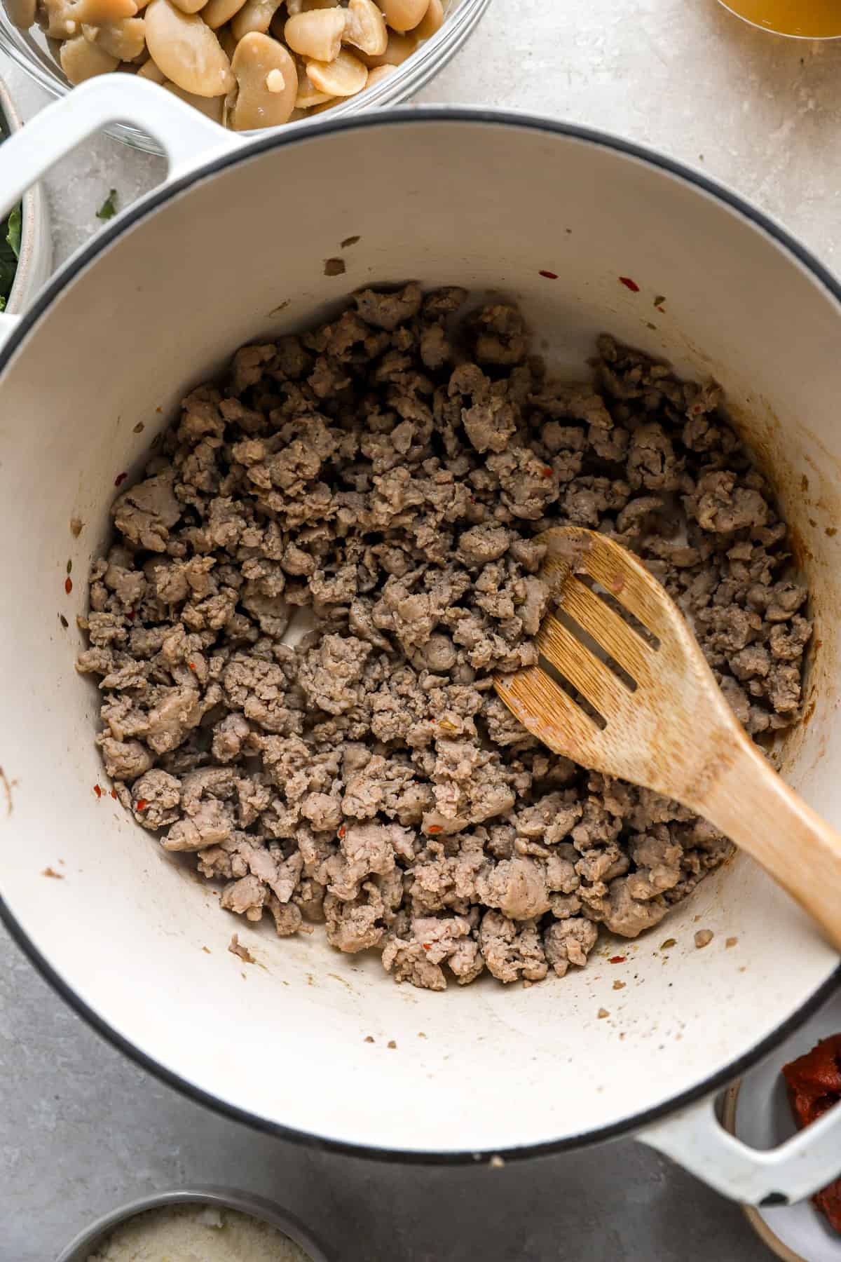 Sausage being browned in a skillet. 