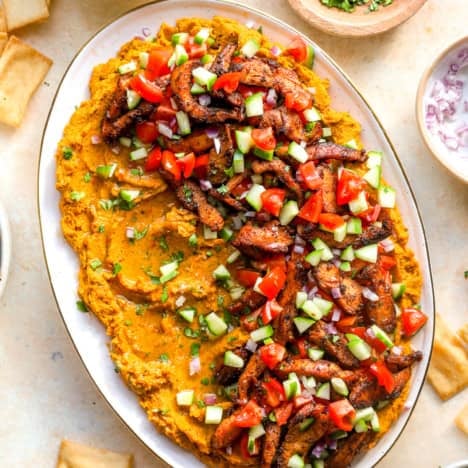 Loaded hummus dip with shawarma chicken on a serving platter.