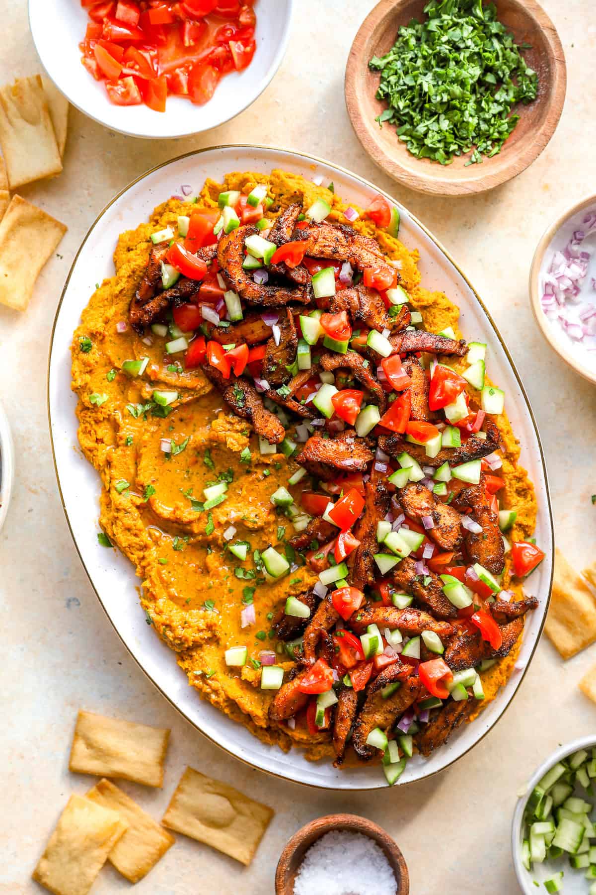 Loaded hummus dip with shawarma chicken on a serving platter.