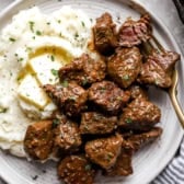 A plate of garlic butter steak bites with mashed potatoes.