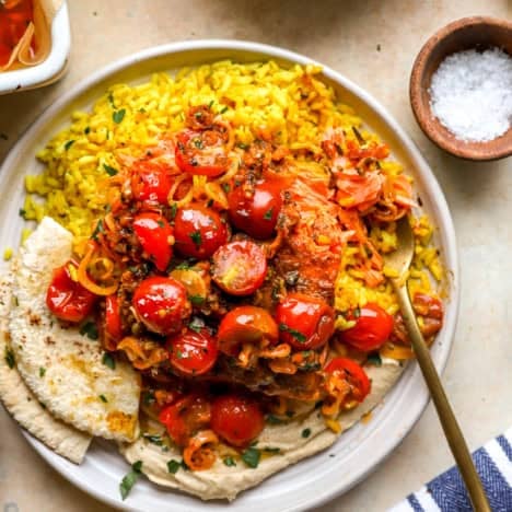 A plate of turmeric rice, pita bread, and salmon shawarma.