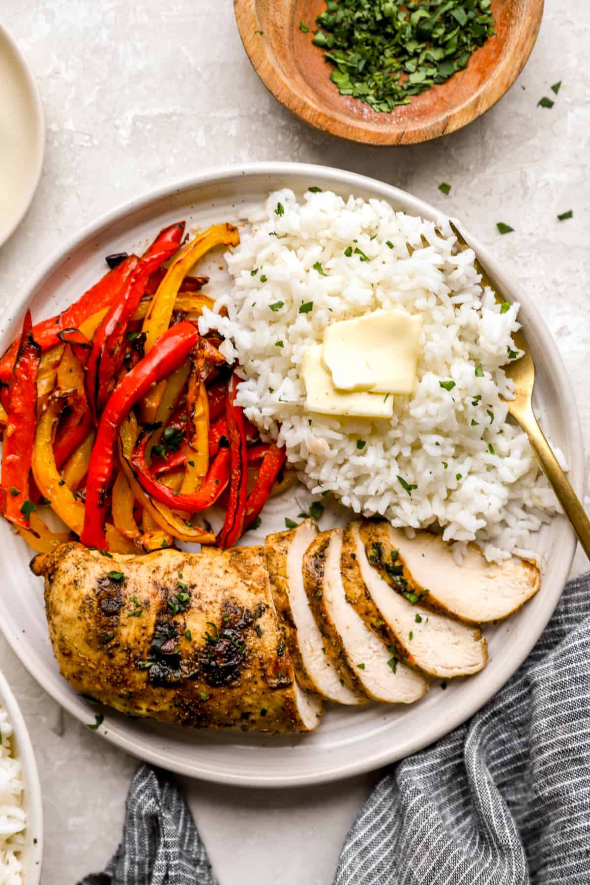 A plate of cooked white rice, chicken, and peppers. 