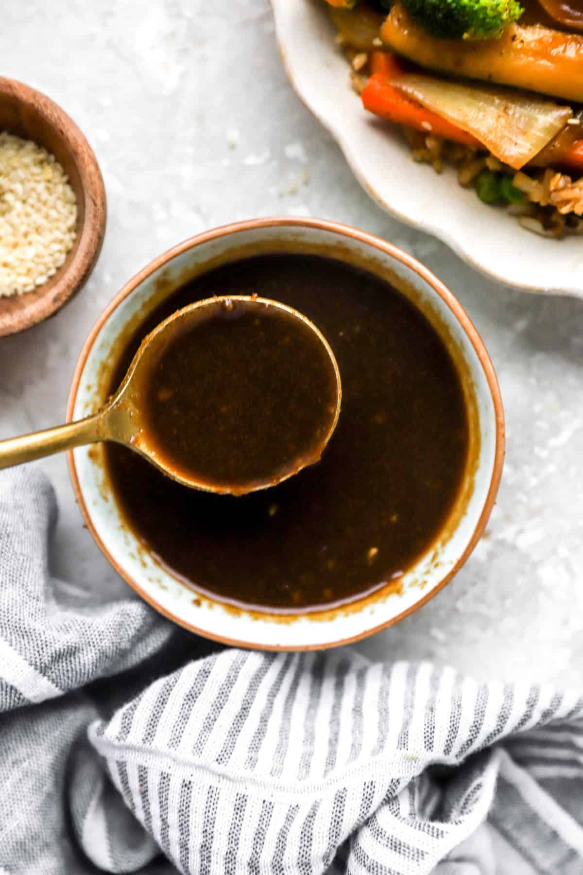 A spoon lifting a scoop of hibachi ginger sauce from a bowl.