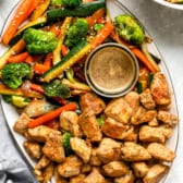 A platter of hibachi vegetables, hibachi chicken, and hibachi ginger sauce.