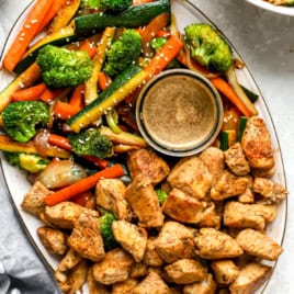 A platter of hibachi vegetables, hibachi chicken, and hibachi ginger sauce.
