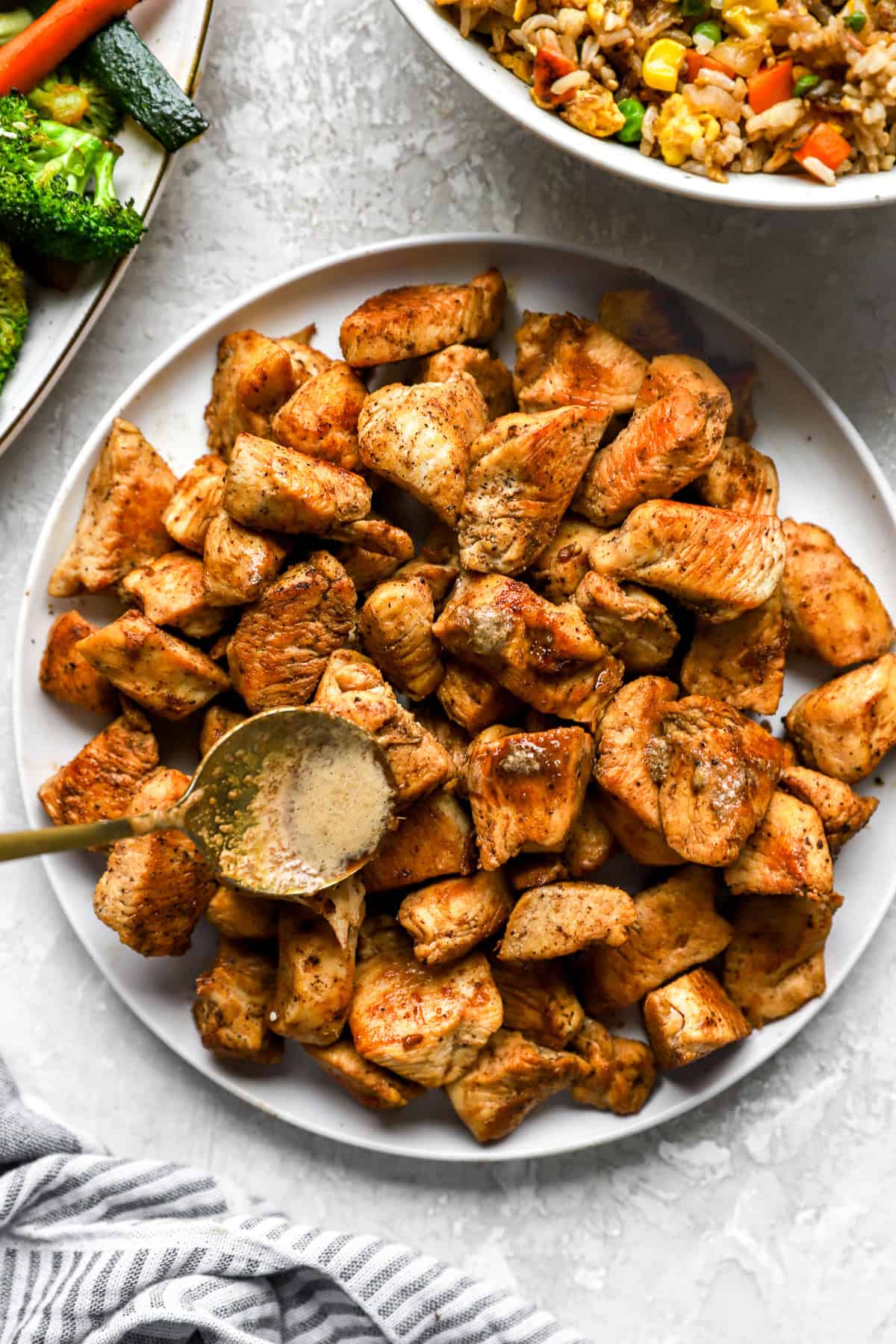 Hibachi ginger sauce being drizzled over a platter of hibachi chicken.