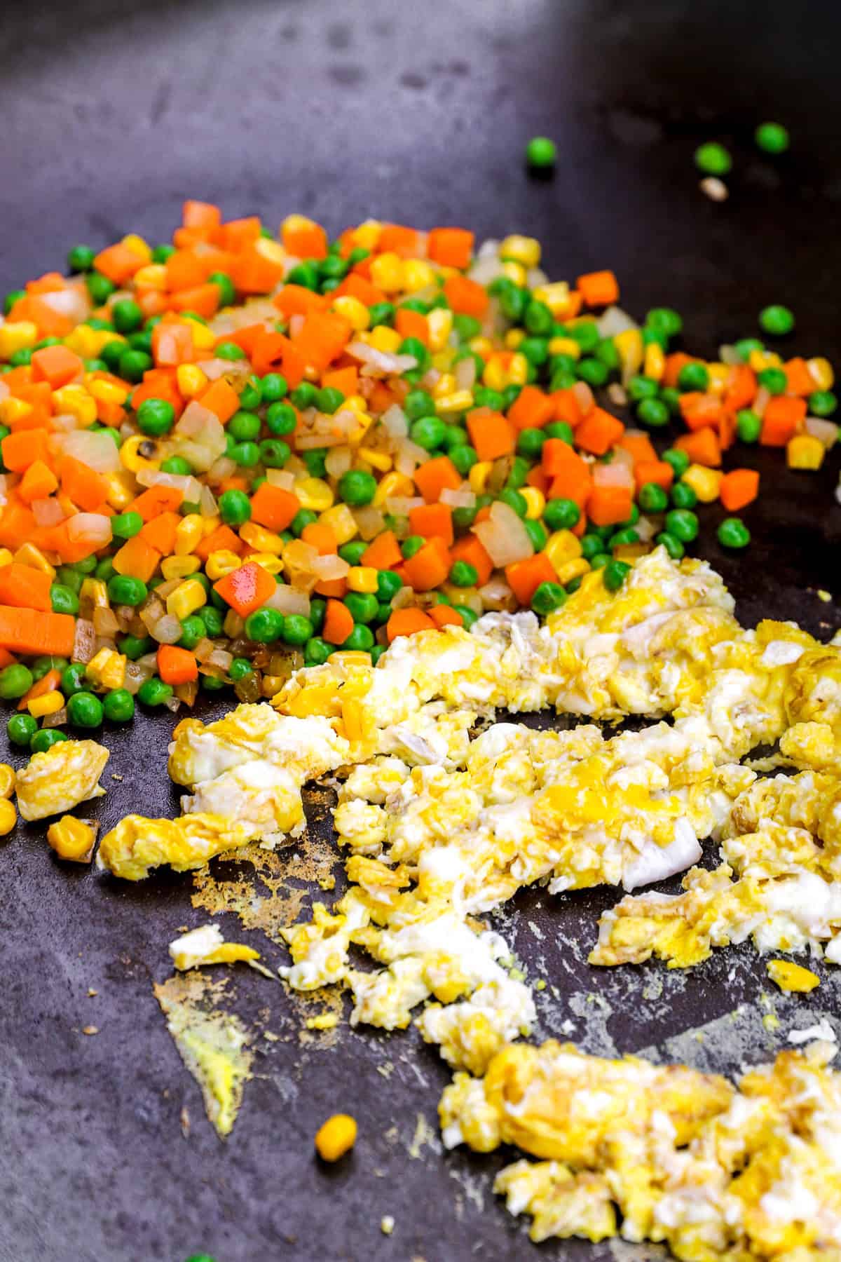 Veggies and scrambled eggs in a skillet.