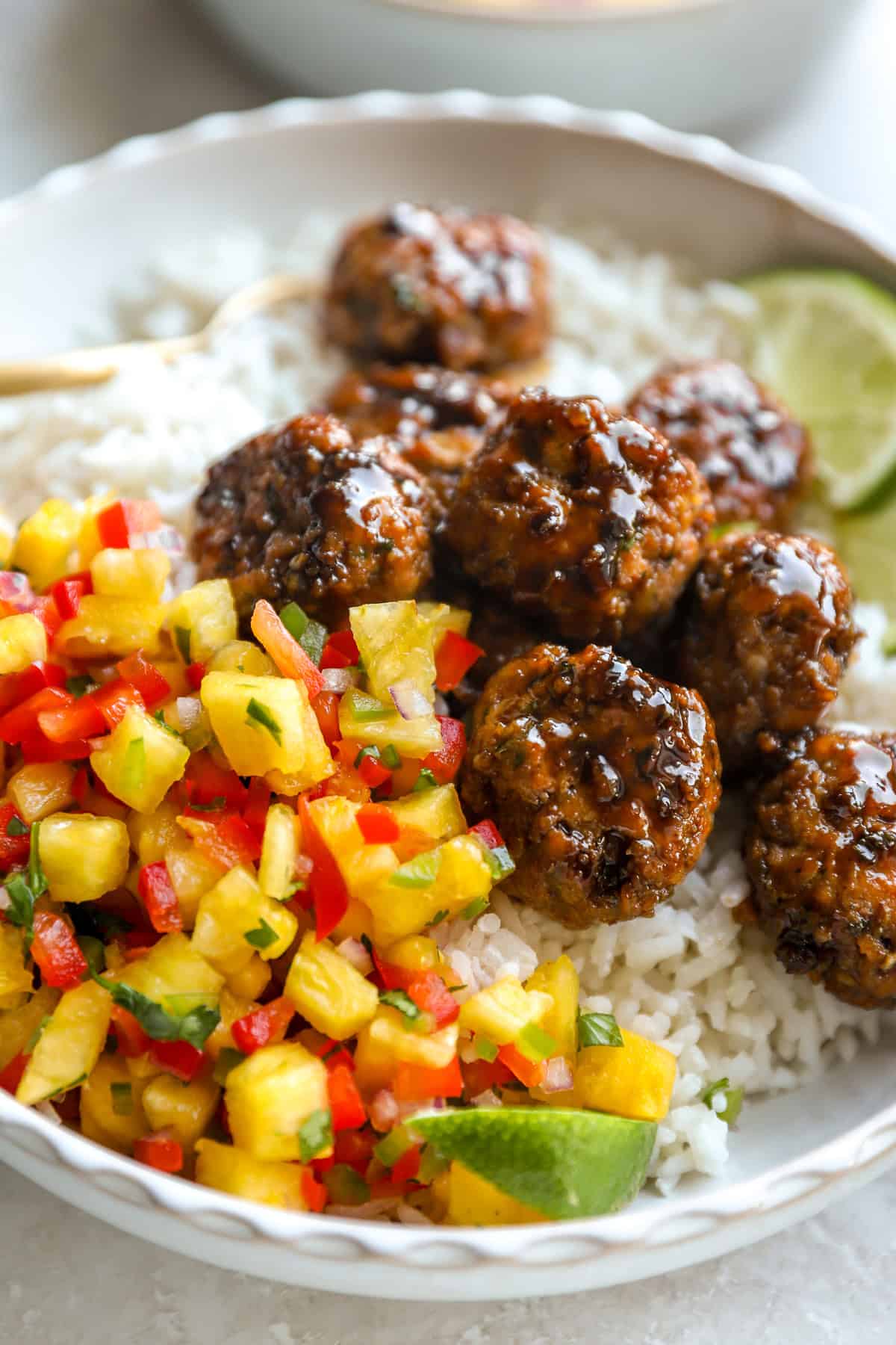 A bowl of coconut rice, honey garlic chicken meatballs, and pineapple salsa.