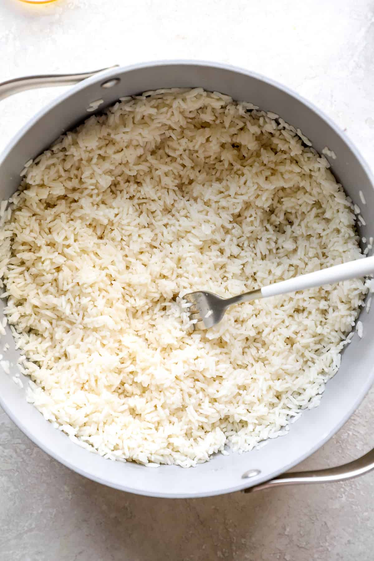 A pot of coconut rice with a fork sticking out.