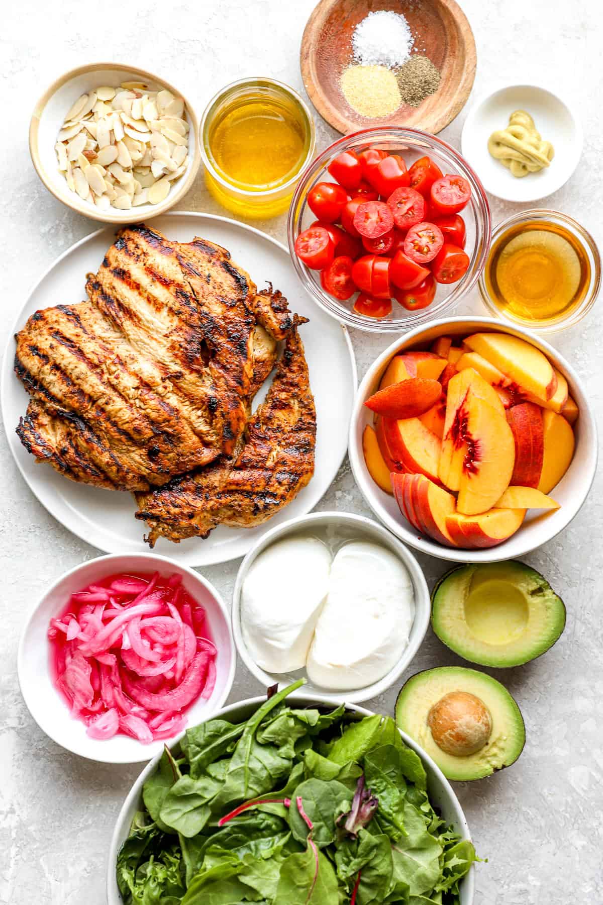 Ingredients to make a peach burrata salad with grilled chicken.