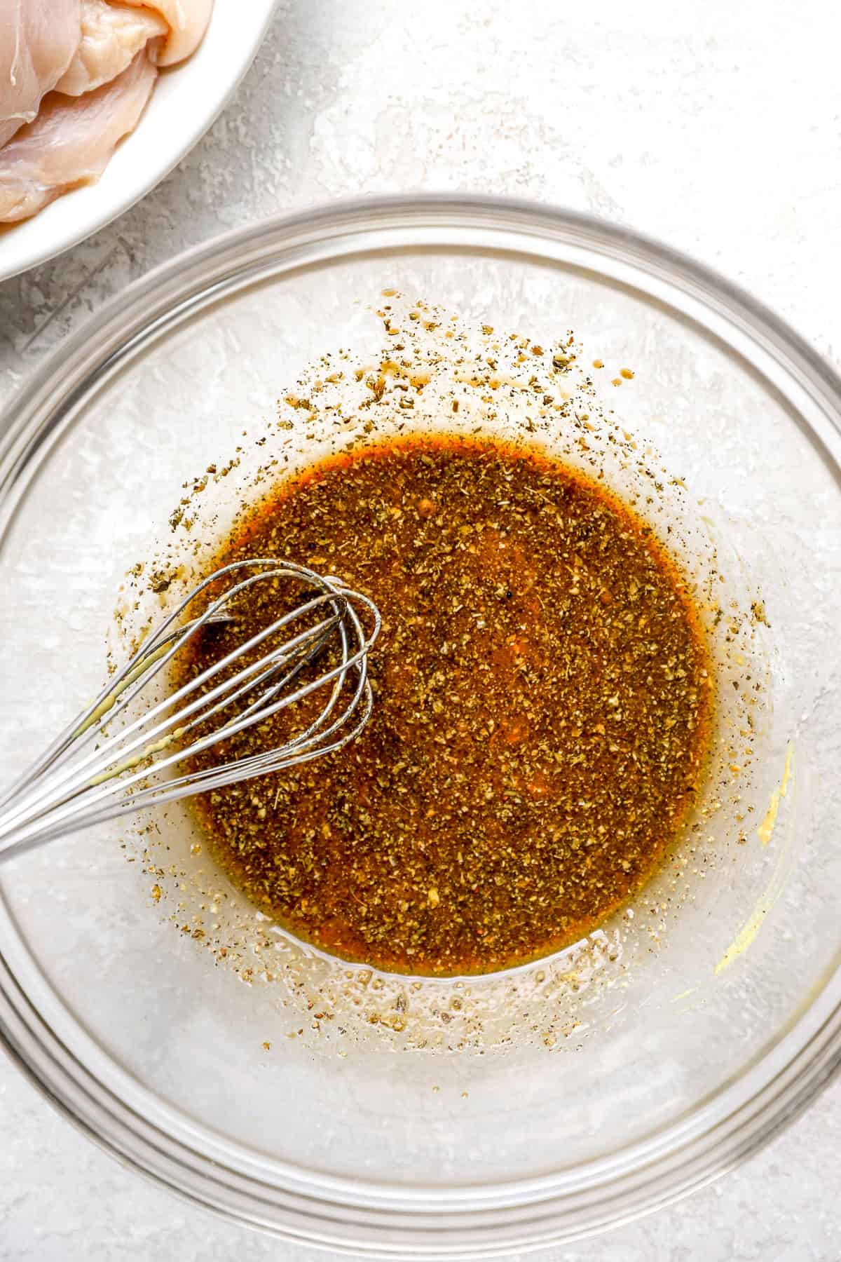 Balsamic marinade in a bowl, a whisk sticking out.