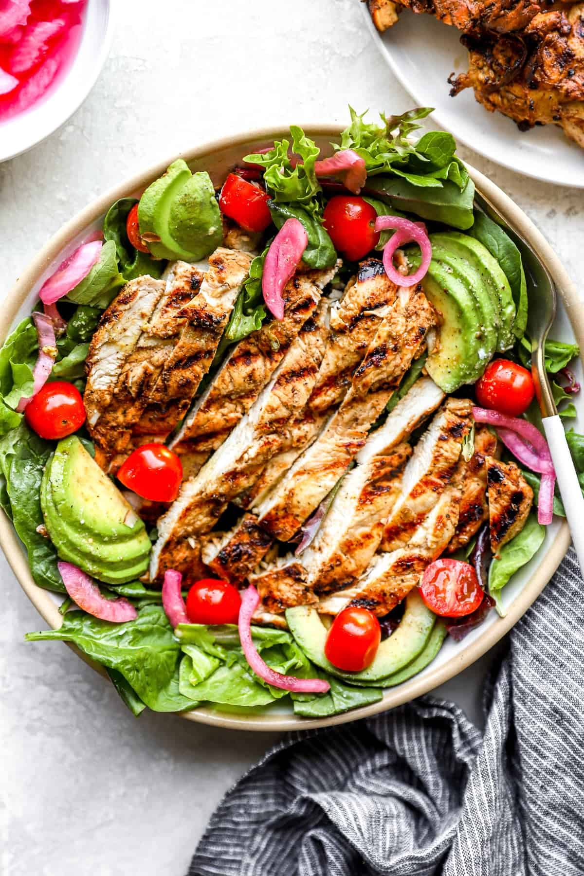 Grilled balsamic chicken breast served over a salad.