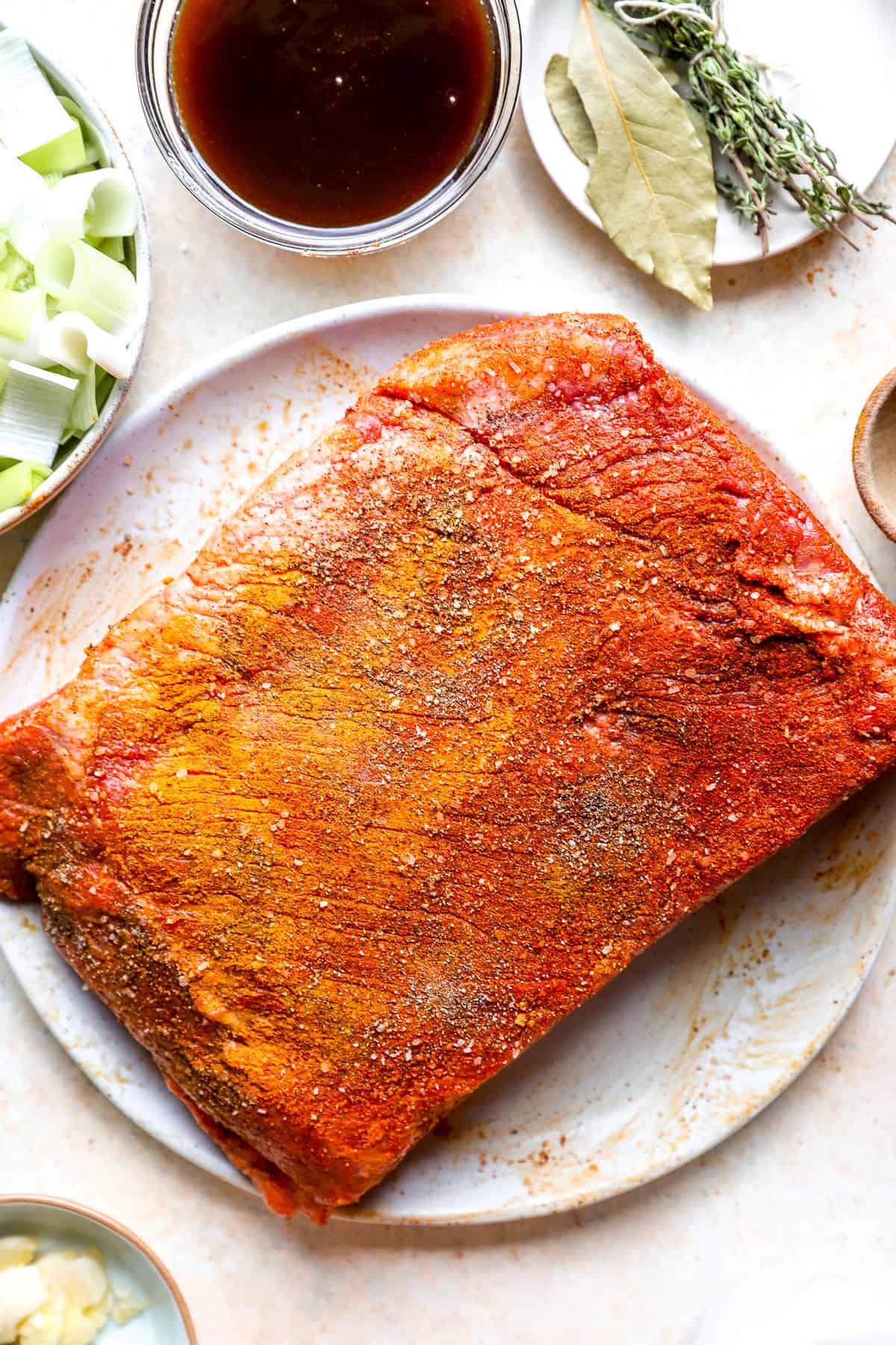 A raw seasoned brisket on a plate.