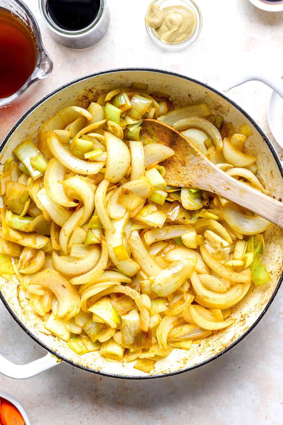 Garlic, onions, and leeks cooking in a pot.