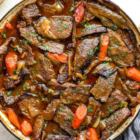 Braised brisket, carrots, and potatoes in a pot.