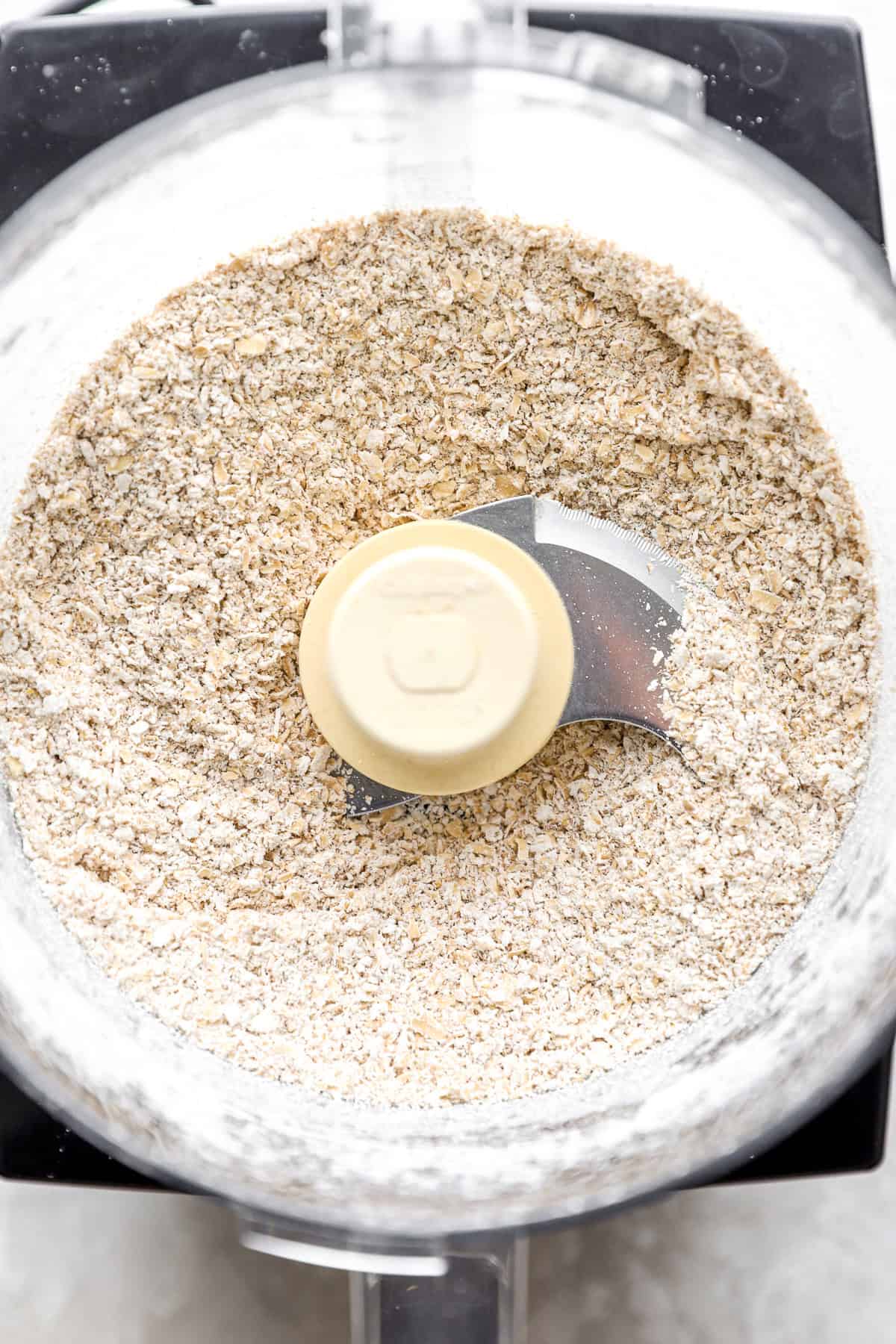 Ground oats in the bowl of a food processor.