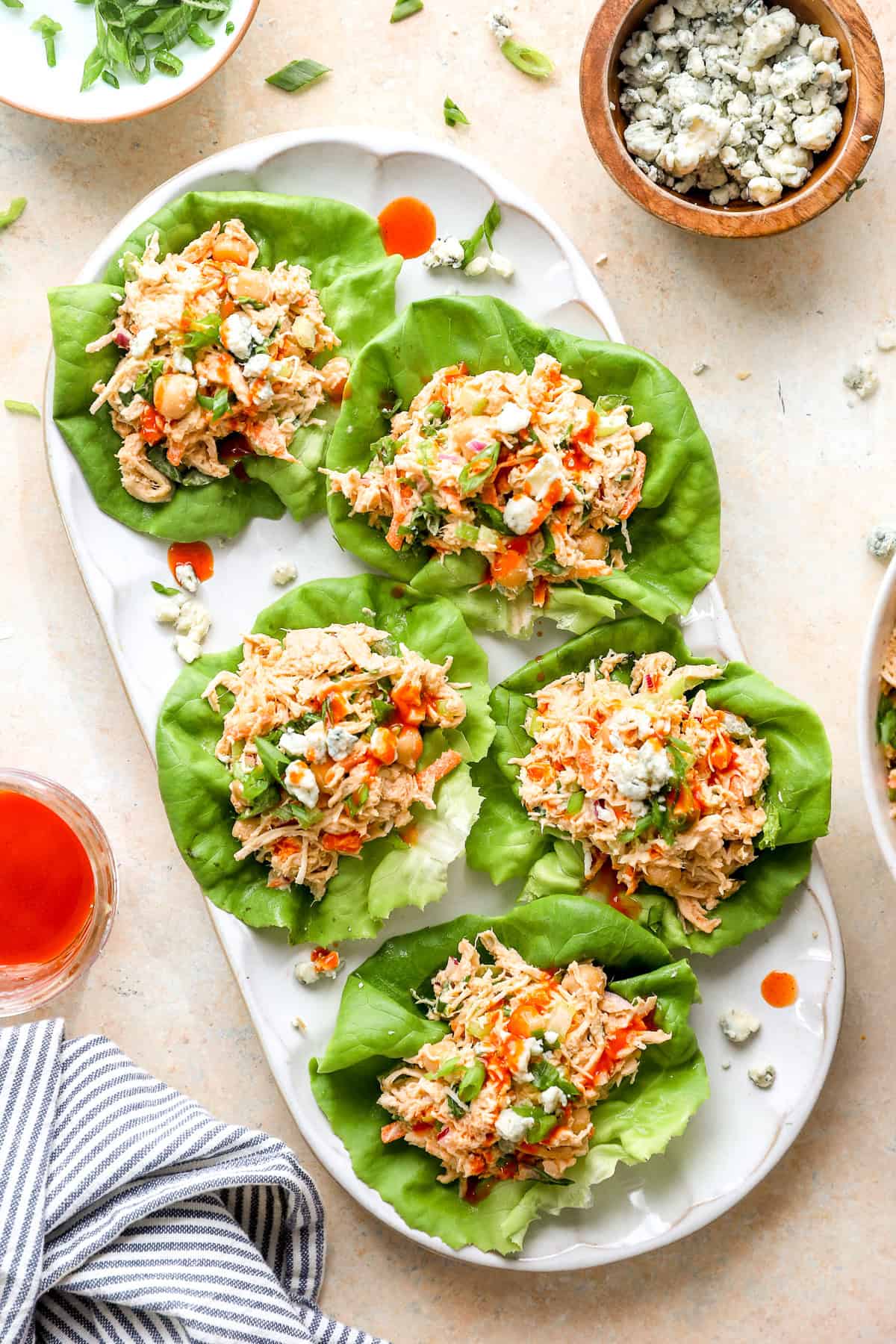 Five buffalo chicken salad lettuce wraps on a platter.
